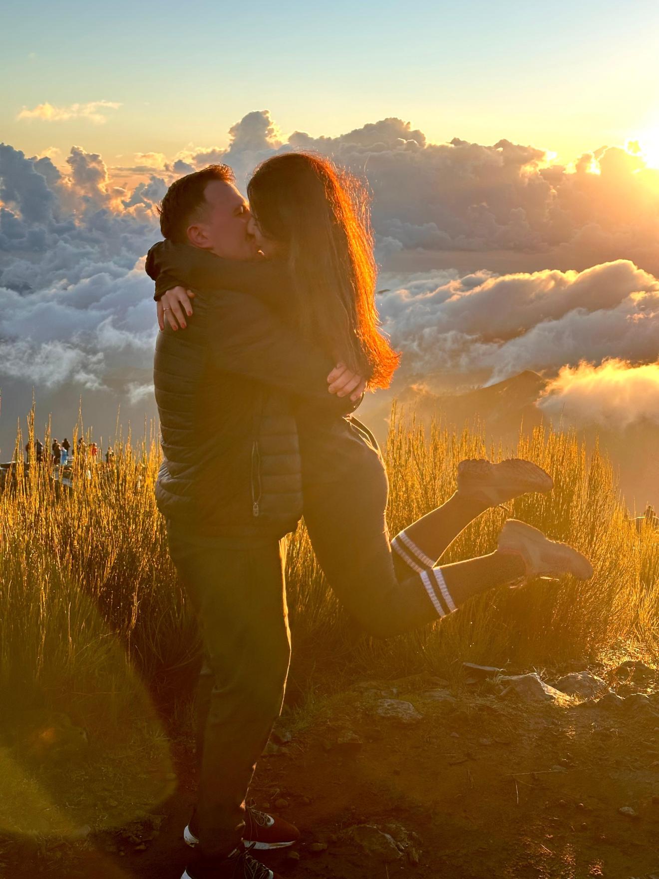 a person standing in front of a sunset