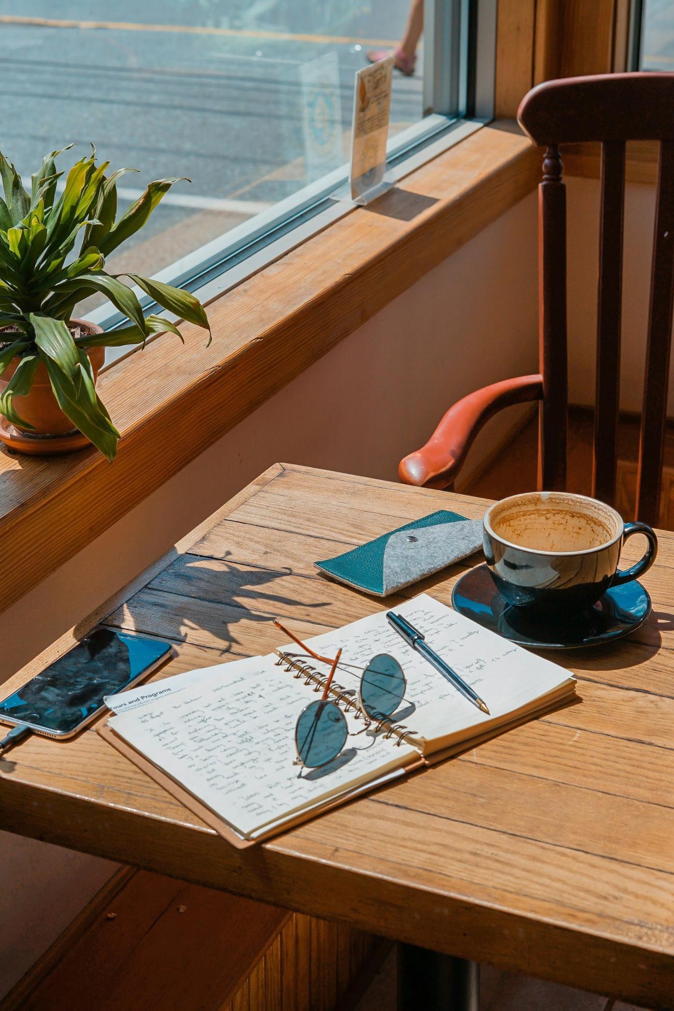 a cup of coffee sitting on top of a wooden table